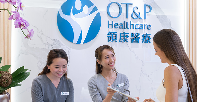 The reception desk with two receptionists greeting a patient at OT&P’s Aesthetics & Wellness Clinic